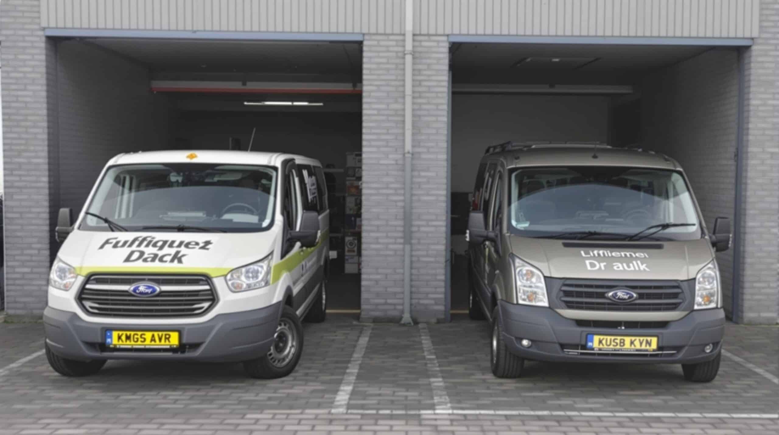 Twee bestelwagens staan naast elkaar geparkeerd, één met een standaard dak en de ander met een verhoogd dak.